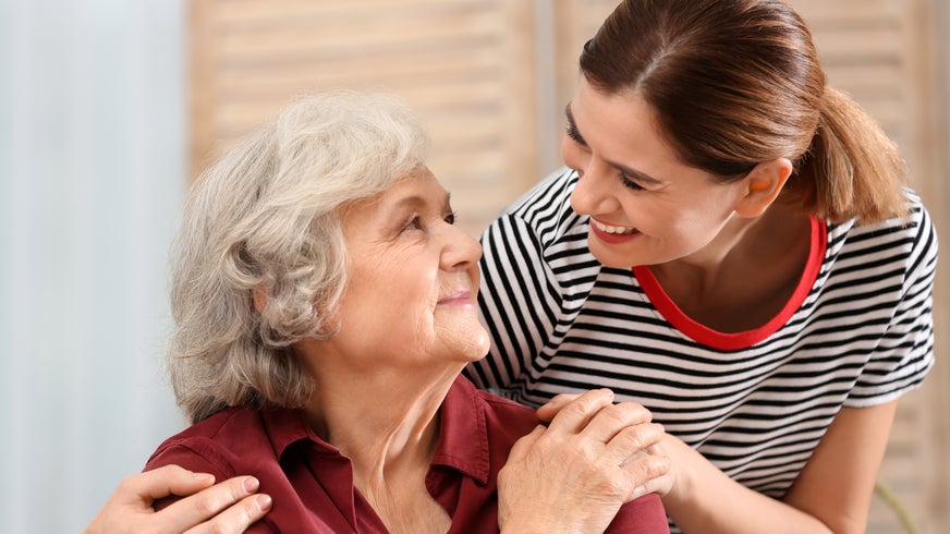 Elderly woman with female caregiver at home.