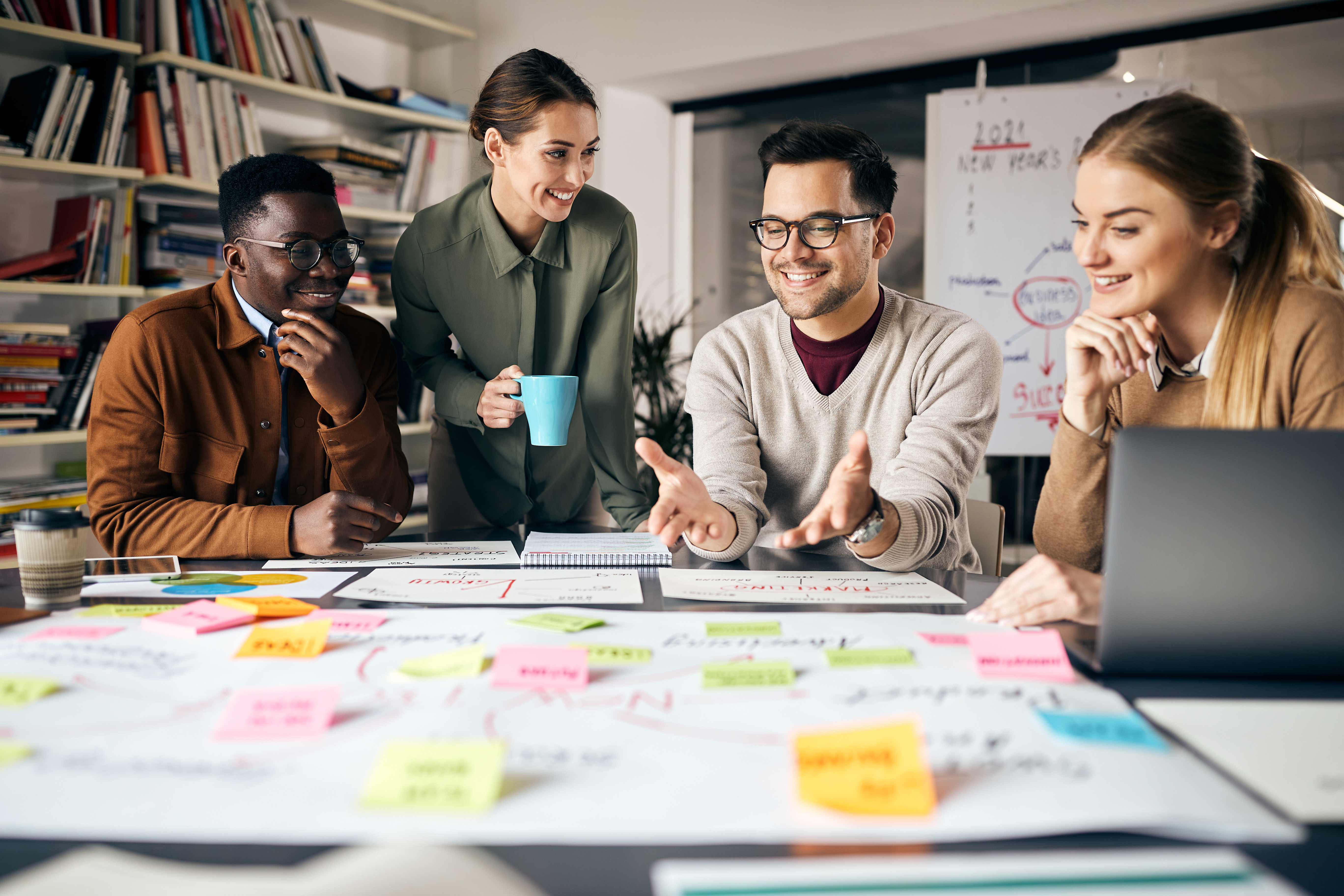 A group of people are sitting around a table with sticky notes on it