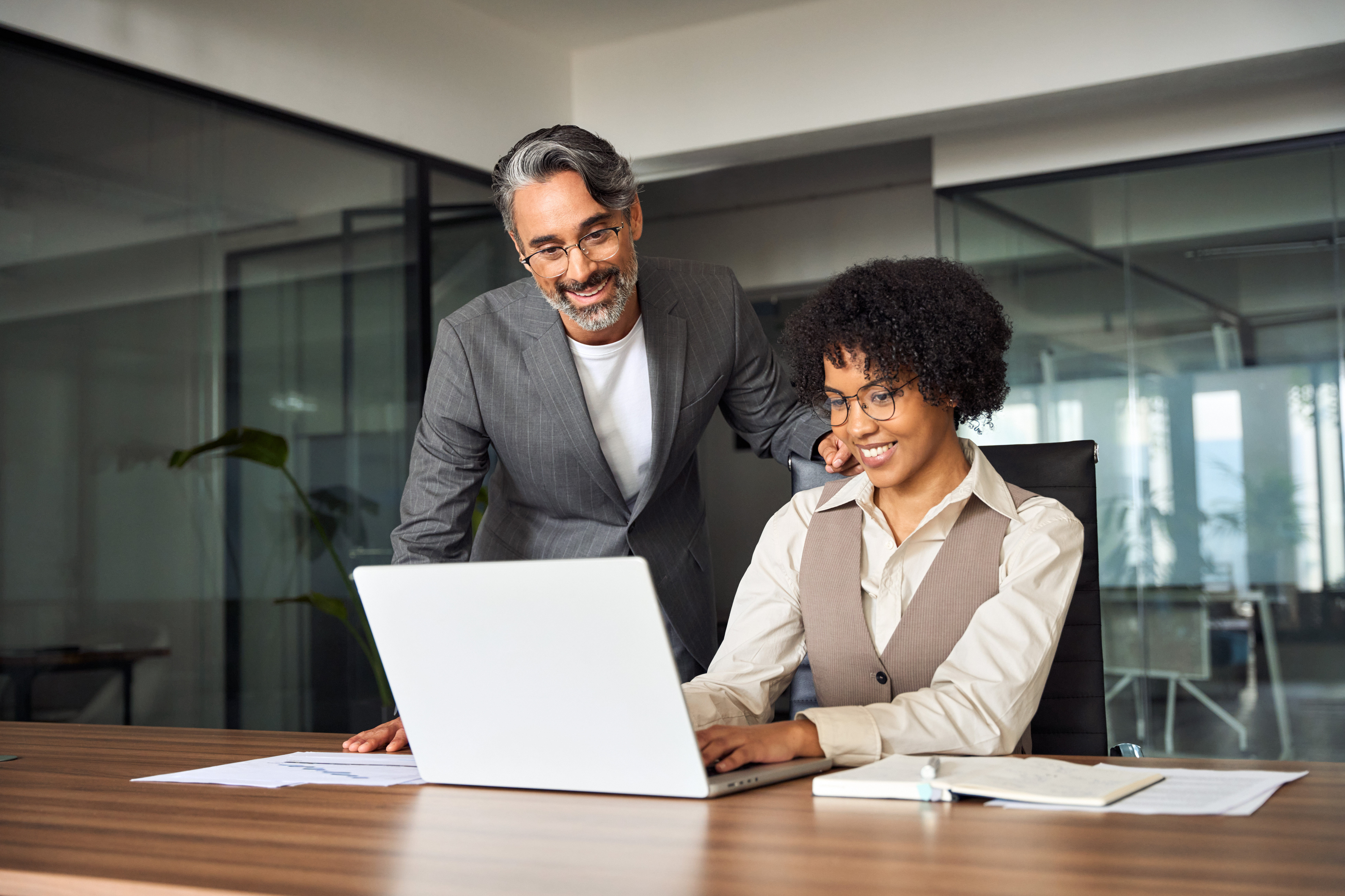 A man and a woman are looking at a laptop computer
