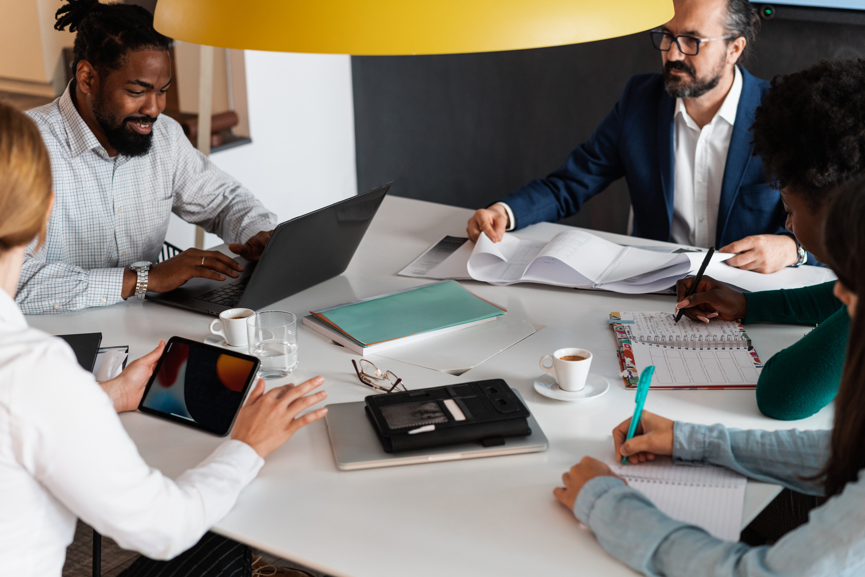 A group of people are sitting around a table having a meeting.