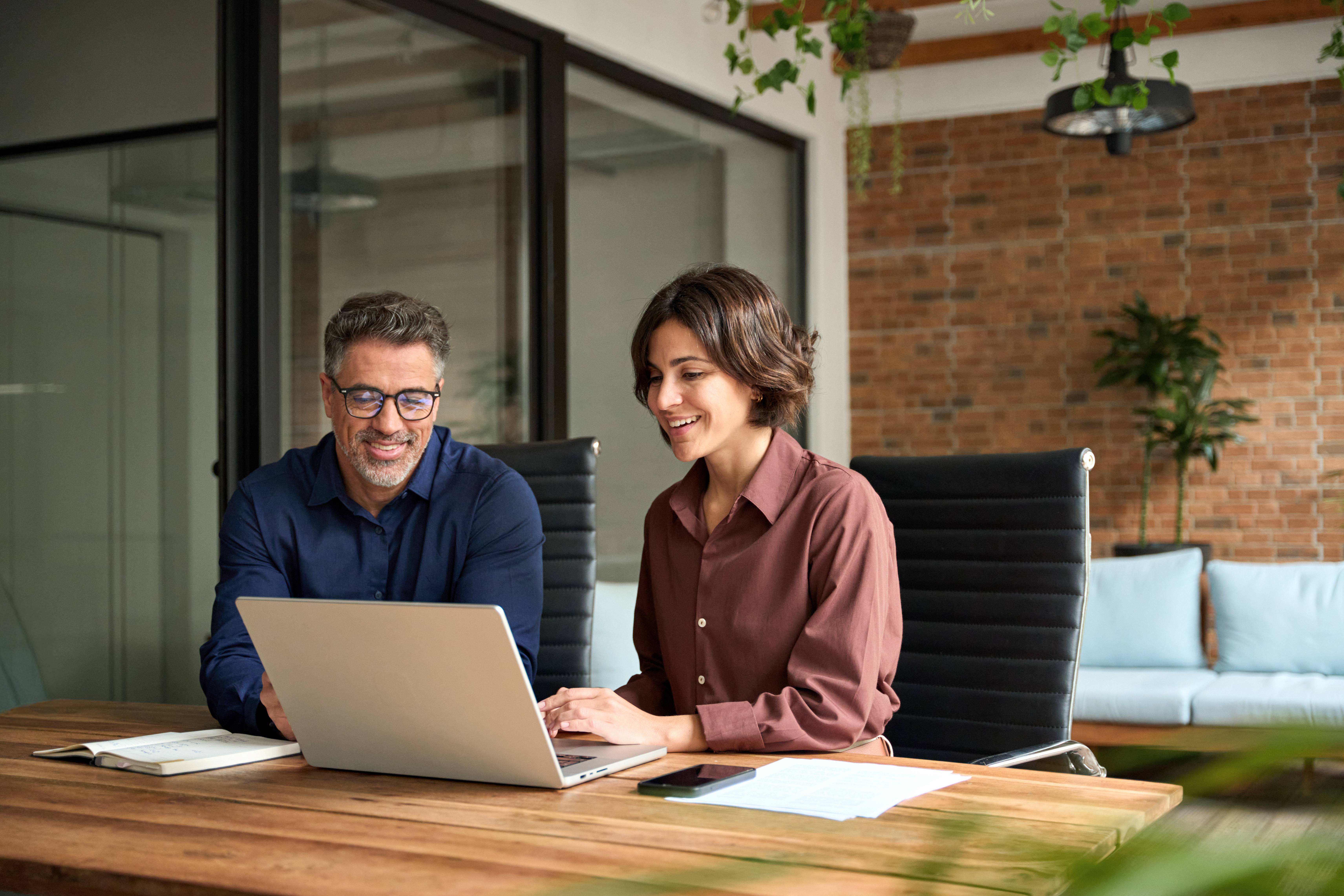 Two office workers looking at computer screen