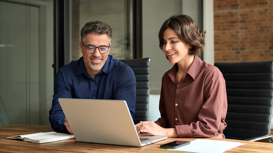 Two office workers looking at computer screen