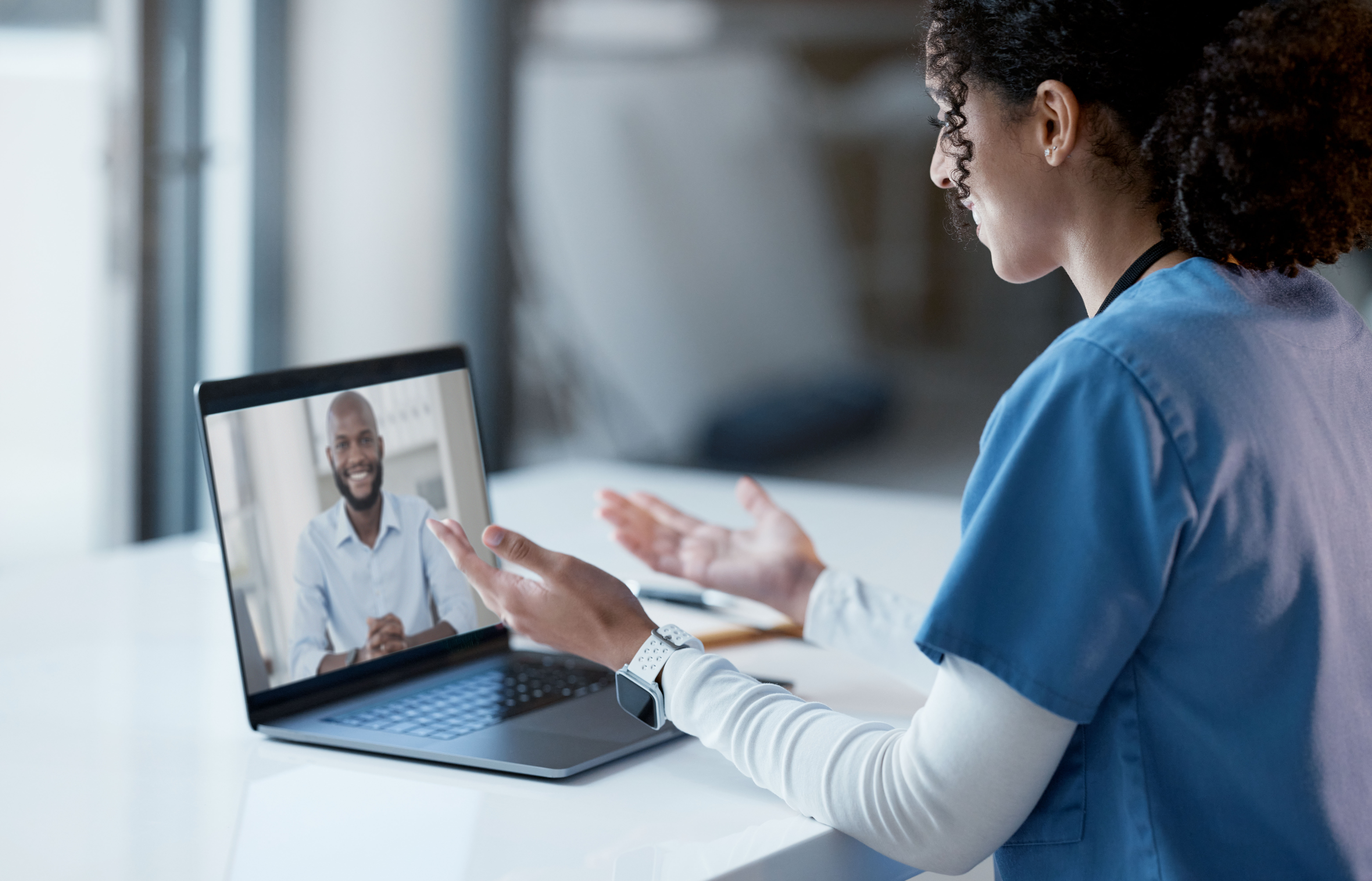 Virtual clinical nurse educator talking through a computer to patient.