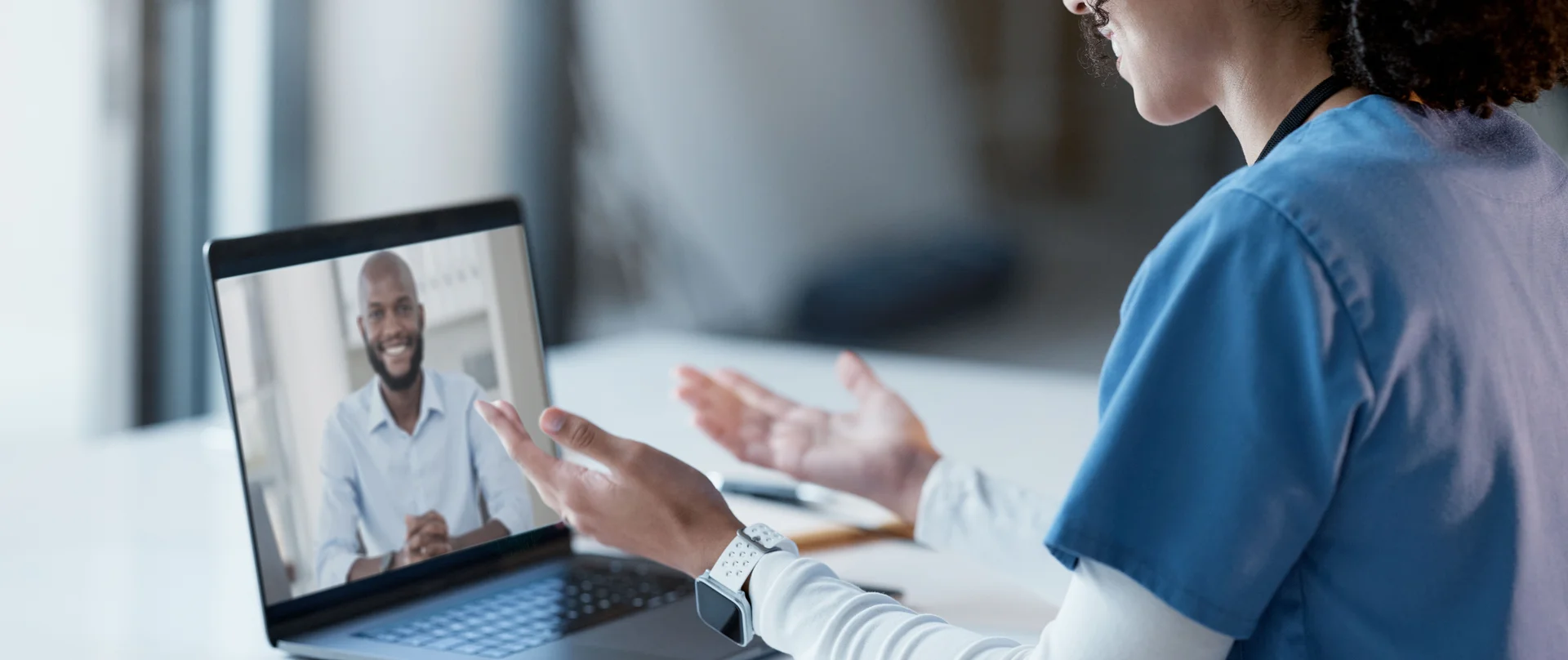 Virtual clinical nurse educator talking through a computer to patient.