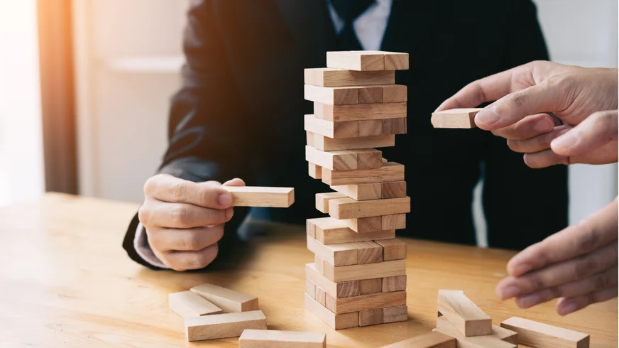 Business men playing jenga