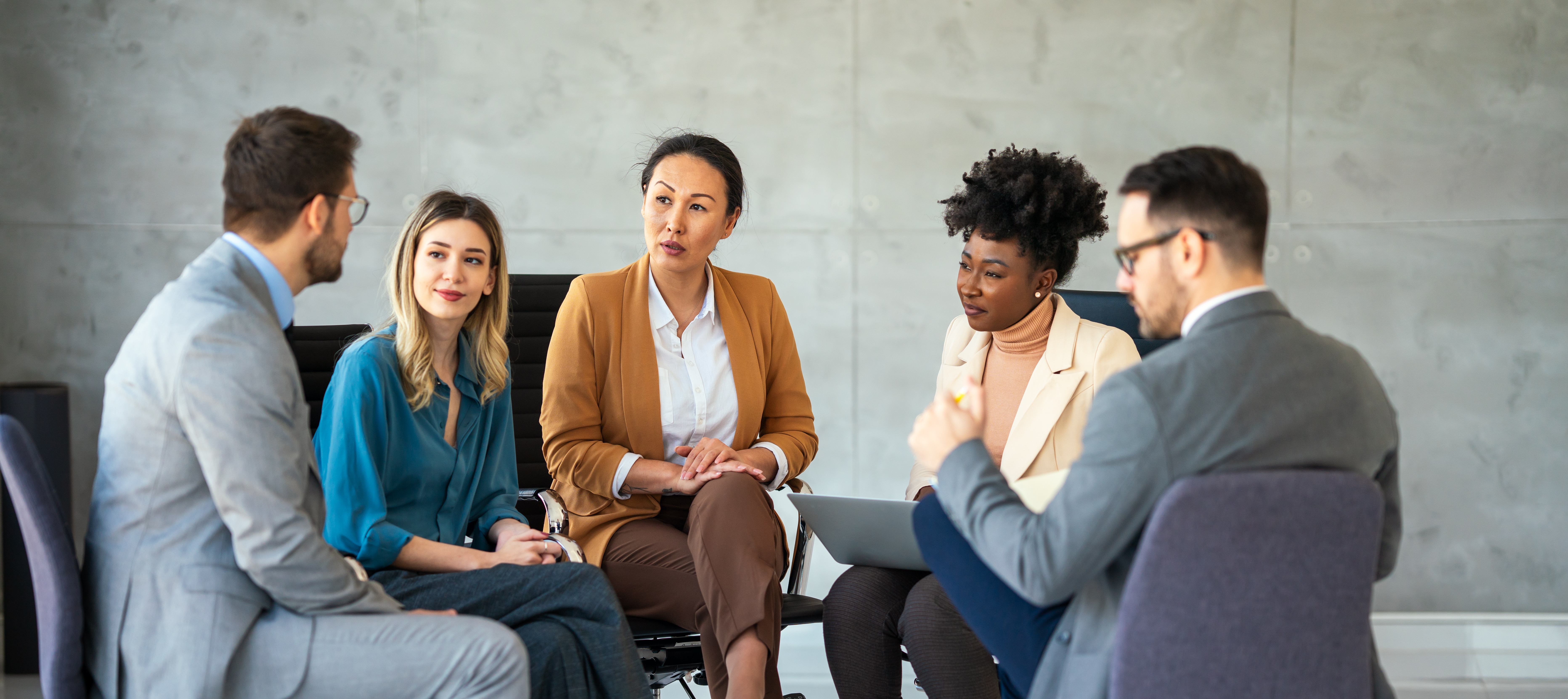 A group of people are sitting in a circle having a meeting