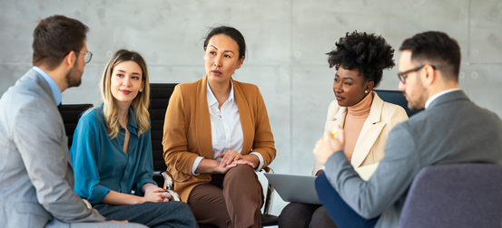 A group of people are sitting in a circle having a meeting