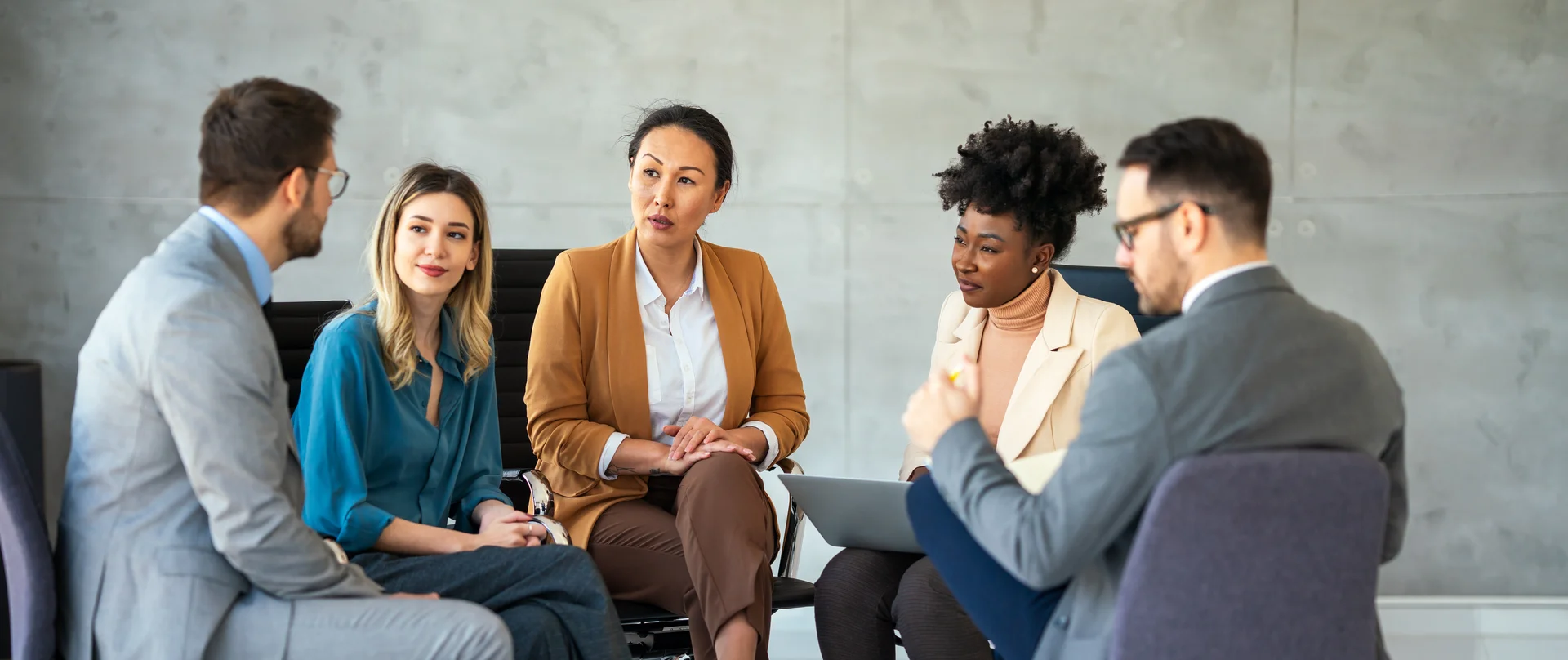 A group of people are sitting in a circle having a meeting