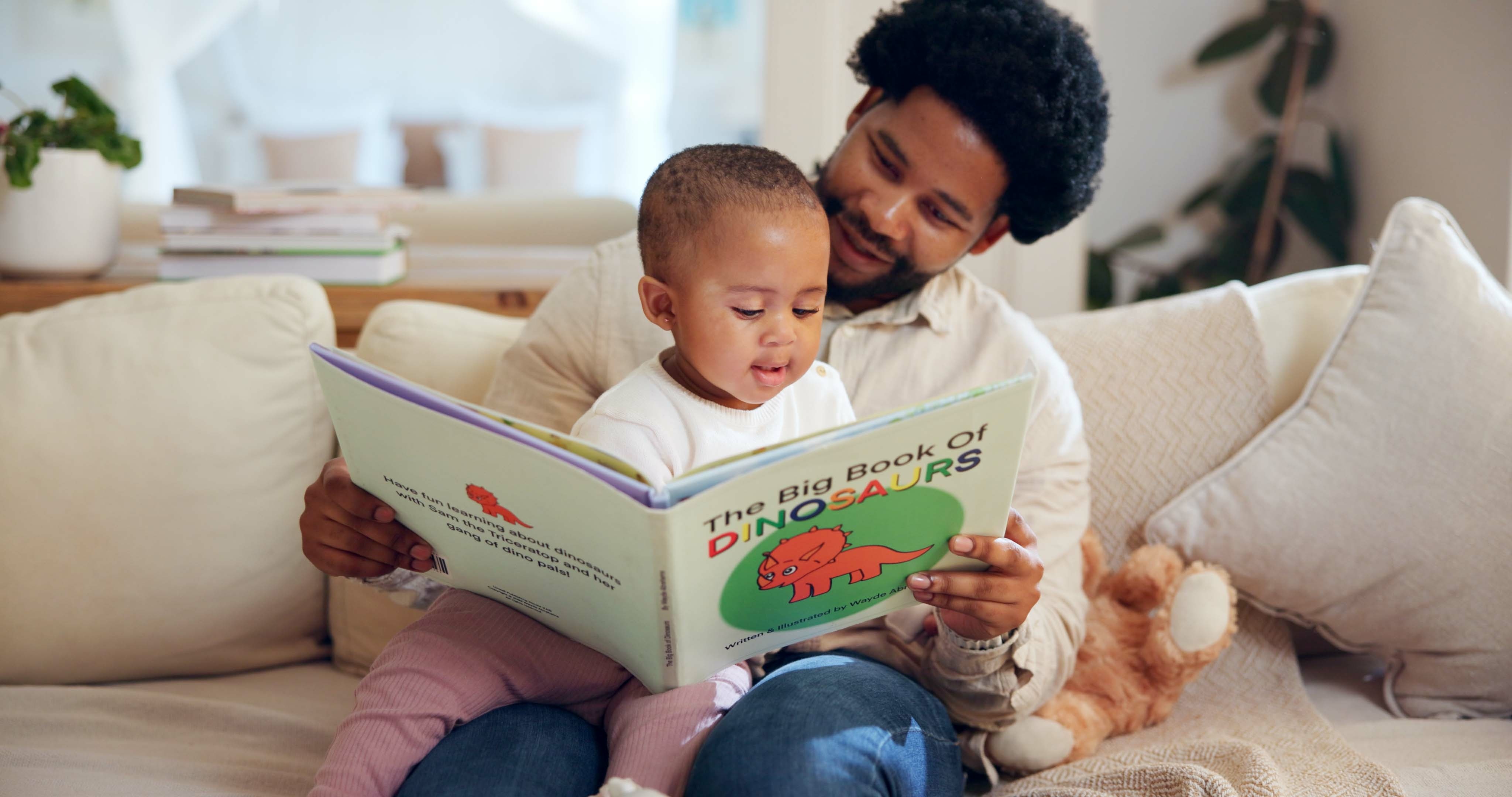 A father and child bonding over "the big book of dinosaurs."