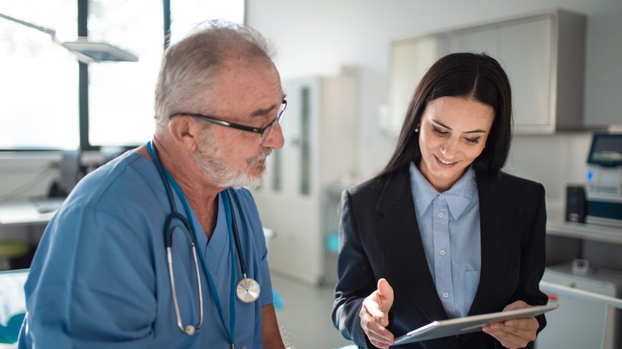 Young pharmaceutic seller explaining something to a doctor in a hospital.