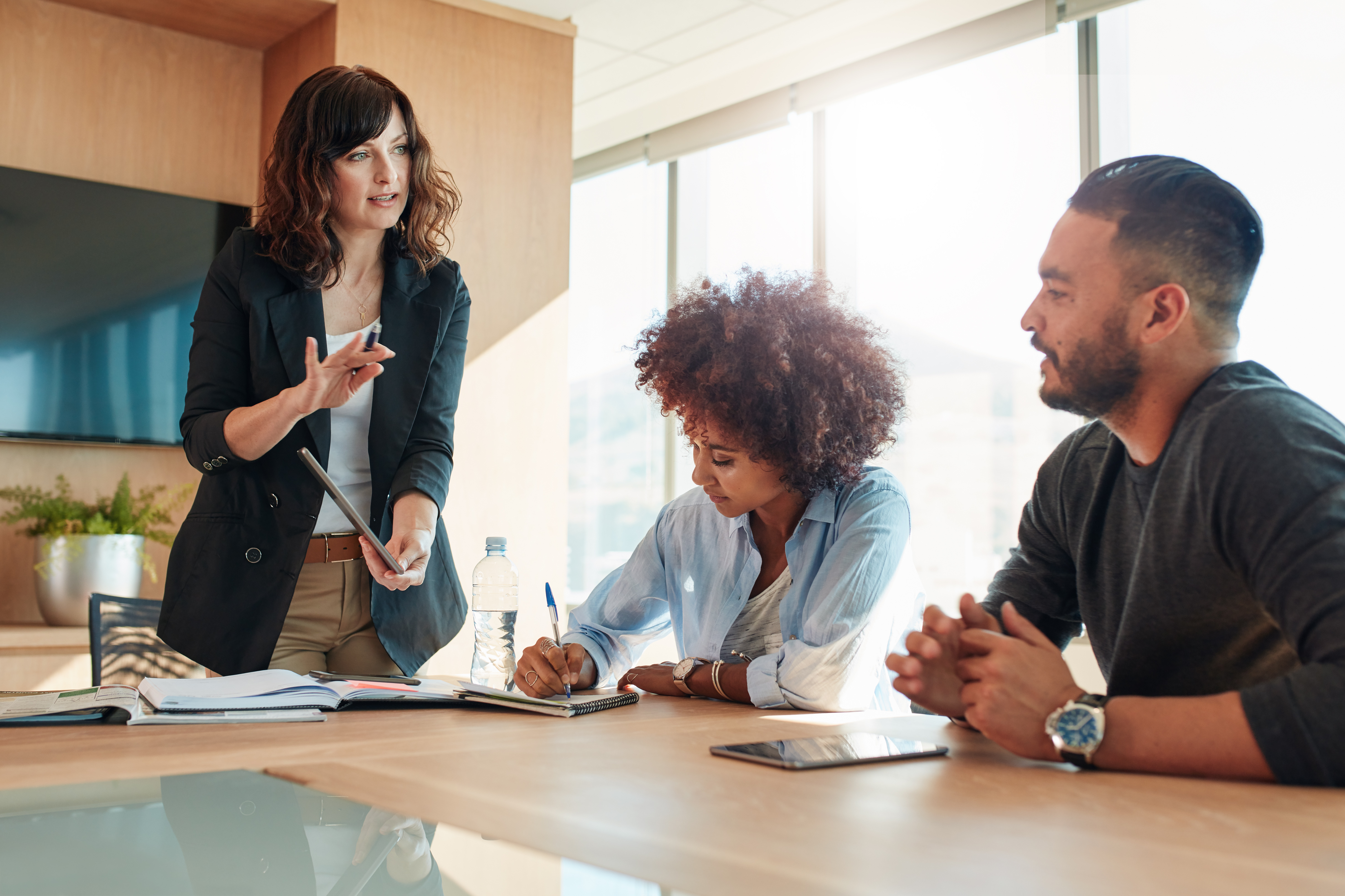 A group of people are sitting around a table having a meeting