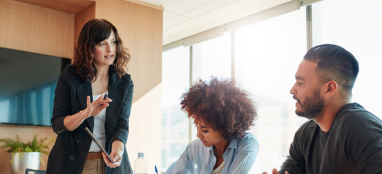 A group of people are sitting around a table having a meeting