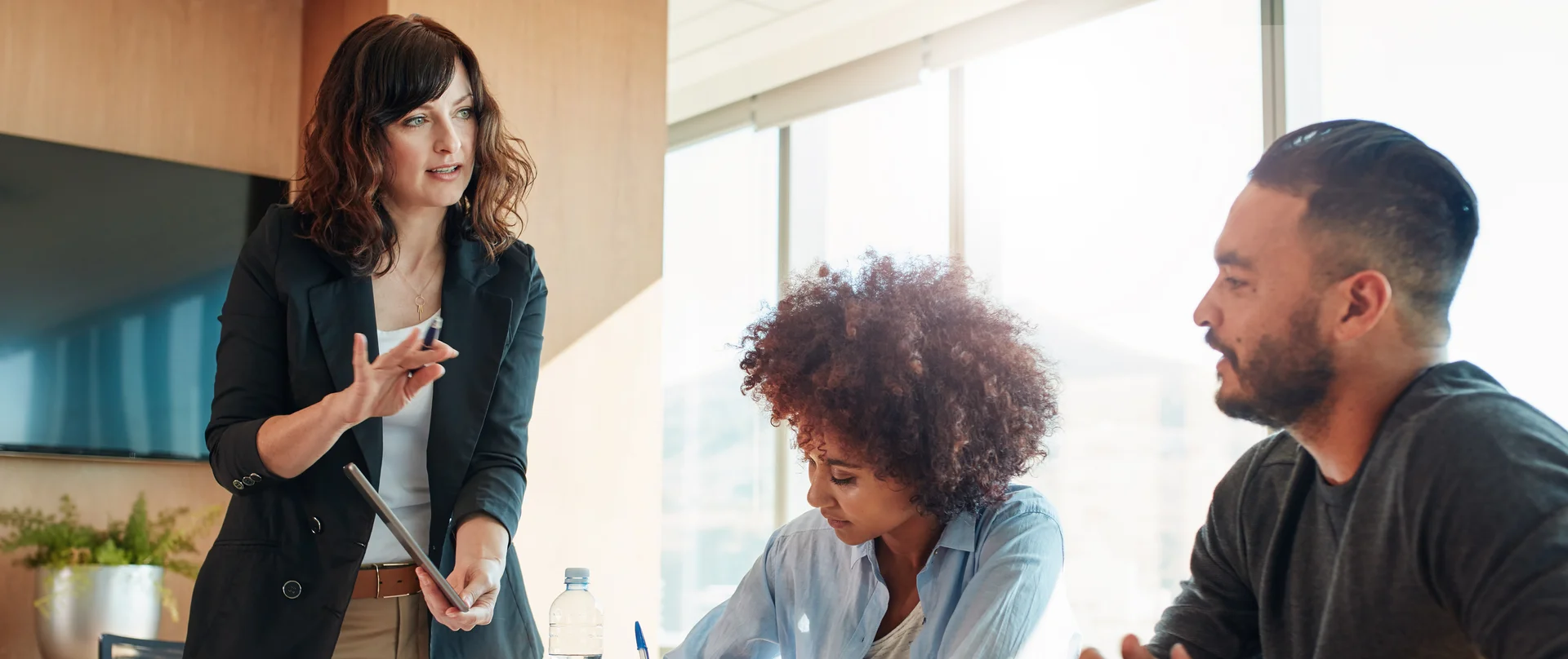 A group of people are sitting around a table having a meeting
