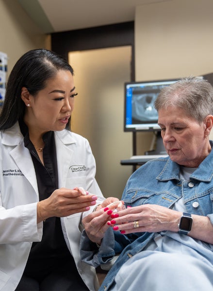 A ClearChoice doctor is talking to a patient in a dental office to understand the dental implant procedure process. 