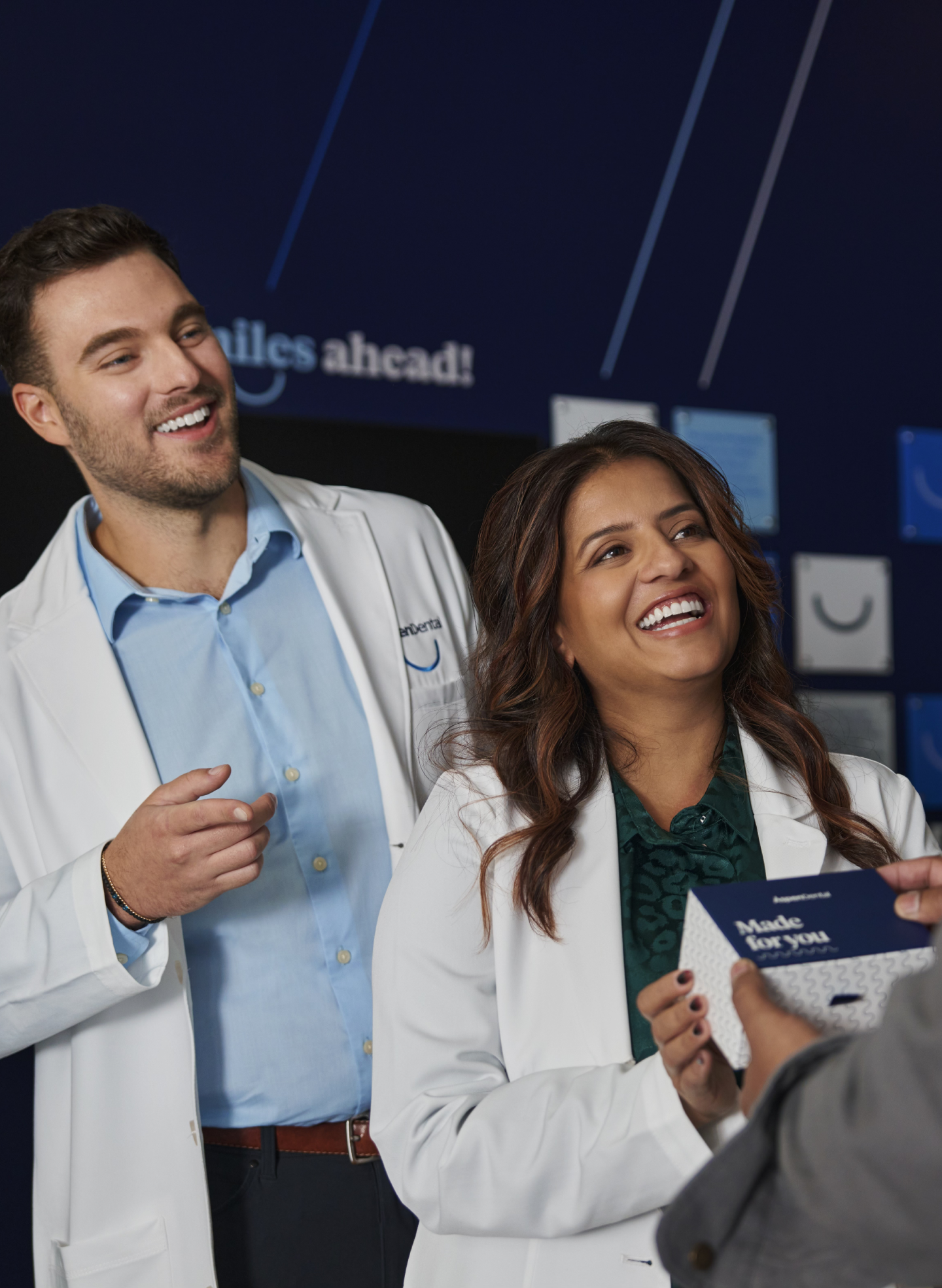 Aspen Dental professionals discussing dental implants vs dental bridges, helping patients choose the best tooth replacement for a confident smile.