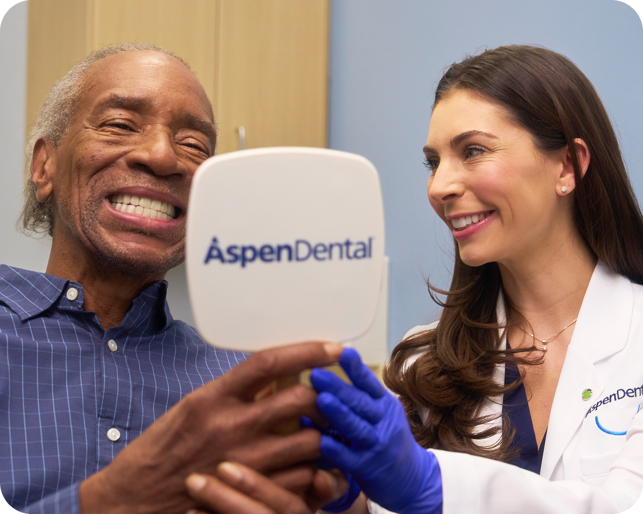 Aspen Dental provider and patient smiling during a denture care checkup visit.