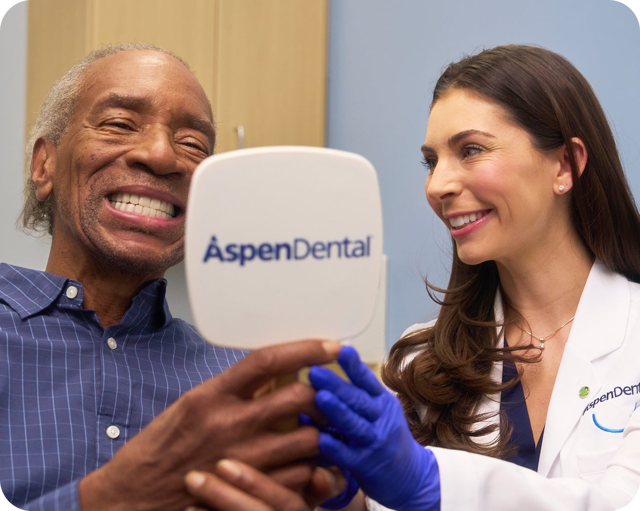 Aspen Dental provider and patient smiling during a denture care checkup visit.