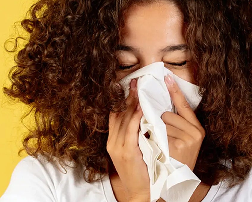 A person blowing their nose.