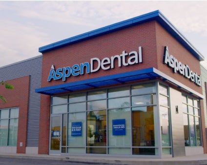 A brick building with the aspen dental logo facade on it. 