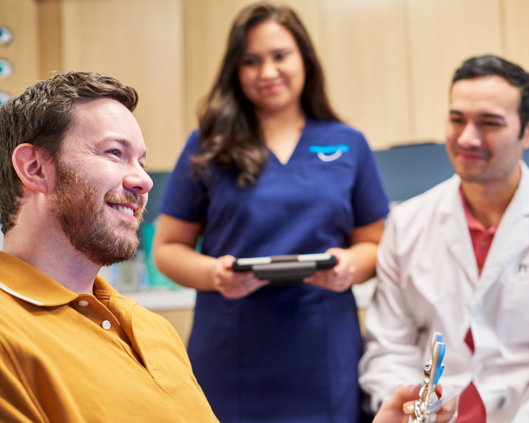 Smiling patient during an orthodontic consultation with dental professionals at the clinic.