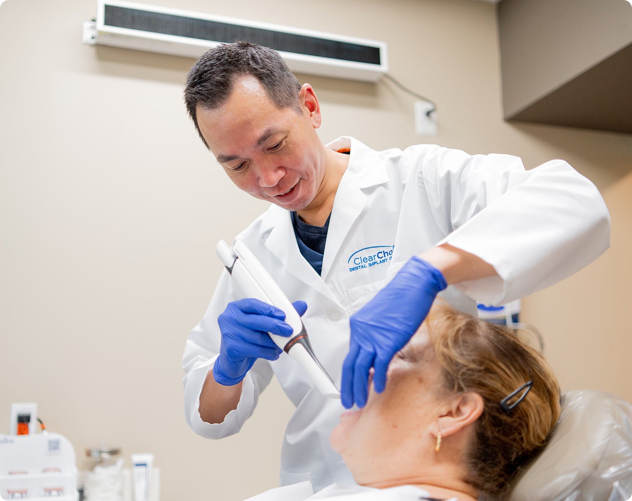 A ClearChoice doctor examining the oral health and teeth condition of his patient to evaluate their eligibility to receive dental implants and the potential need for additional procedures.