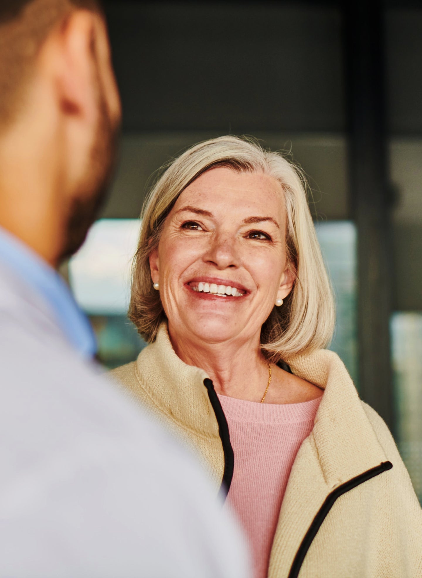 Smiling woman in a dental office discussing permanent dental implants with her dentist.
