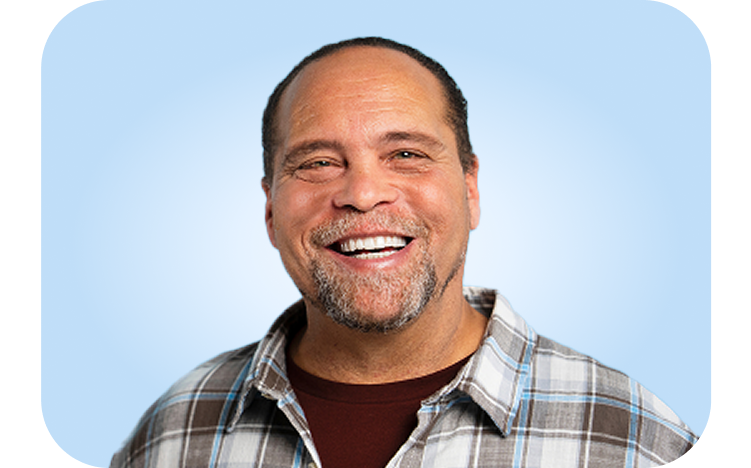 Smiling male showing restored confidence after dental implant treatment at Aspen Dental.