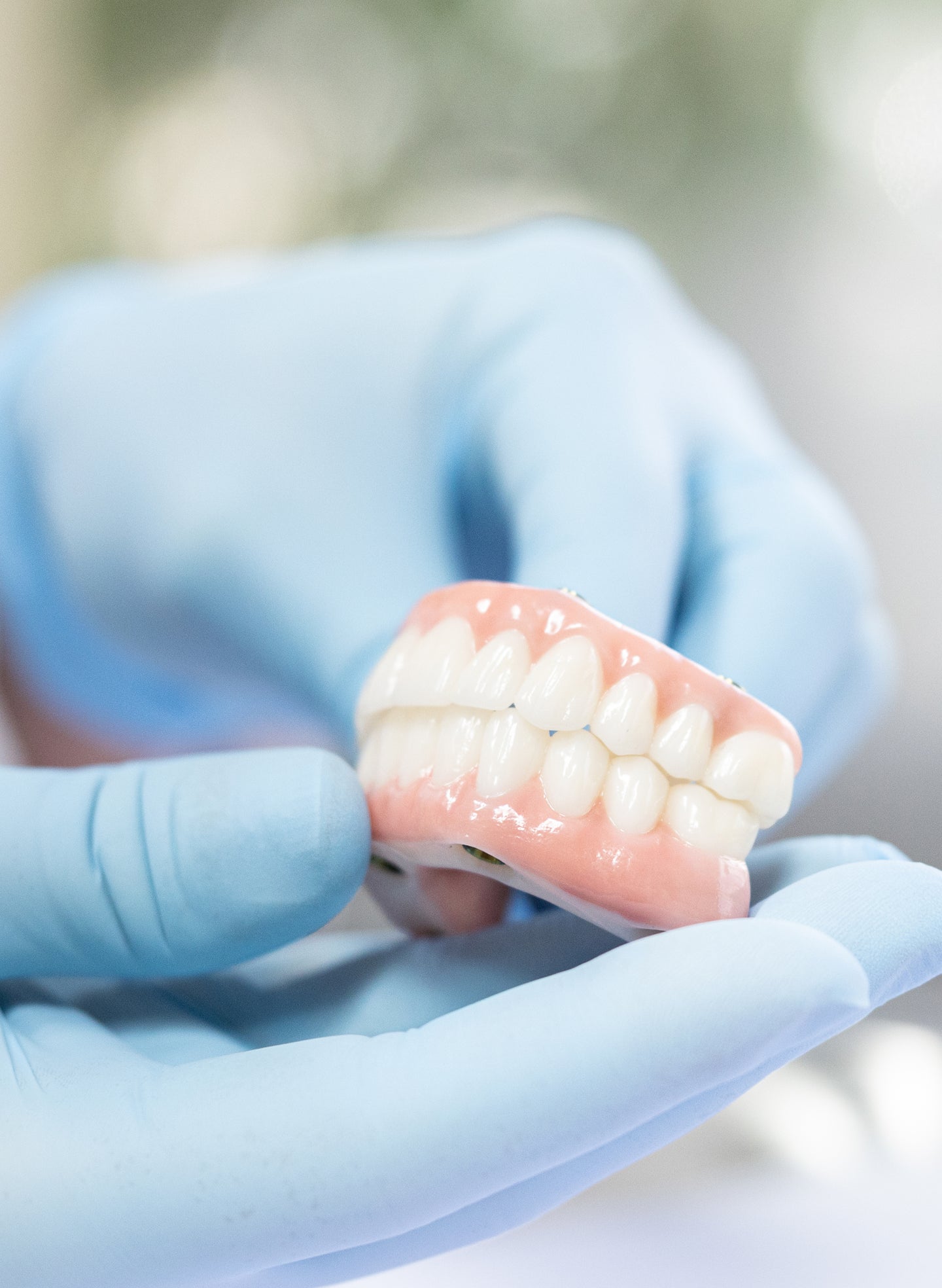 An image of a ClearChoice doctor holding a full arch dental implants model while explaining to their patients insurance coverage and other payment options for dental implants.