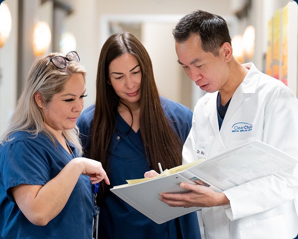 An image of ClearChoice dental implant professionals discussing patient treatment plan options.