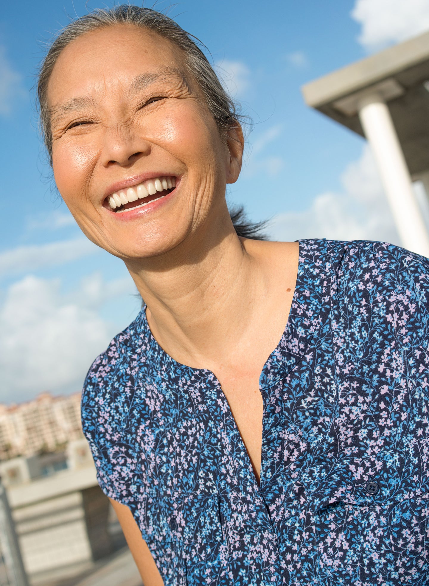 Smiling senior woman outdoors on a sunny day, representing confidence and joy after sinus lift surgery for dental implants with ClearChoice.