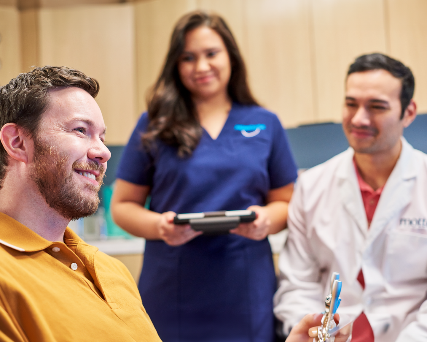 Smiling patient during an orthodontic consultation with dental professionals at the clinic.