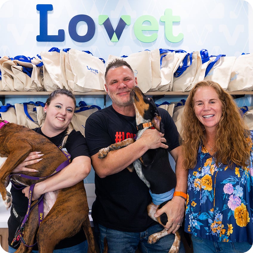  LovePup team holding dogs and smiling at Queen Creek open house event.