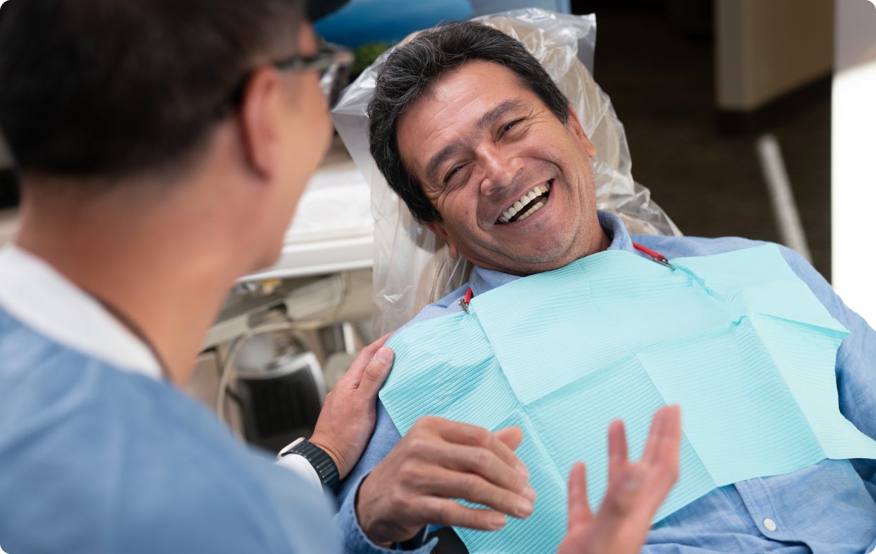 A patient at his final appointment, having completed all steps of his dental implant restoration, and listening to the post-care instructions given by his ClearChoice provider.