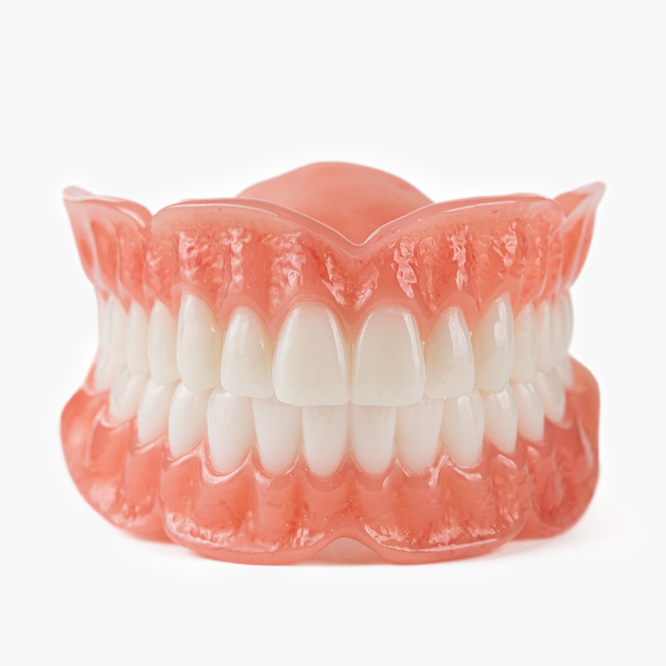 Full set of Aspen Dental permanent dentures, showcasing the SigElite design with natural-looking teeth and gum structure.