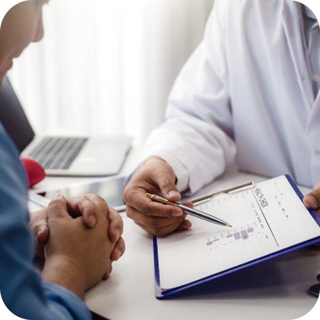 A medical provider pointing to paperwork, explaining test results to a patient.