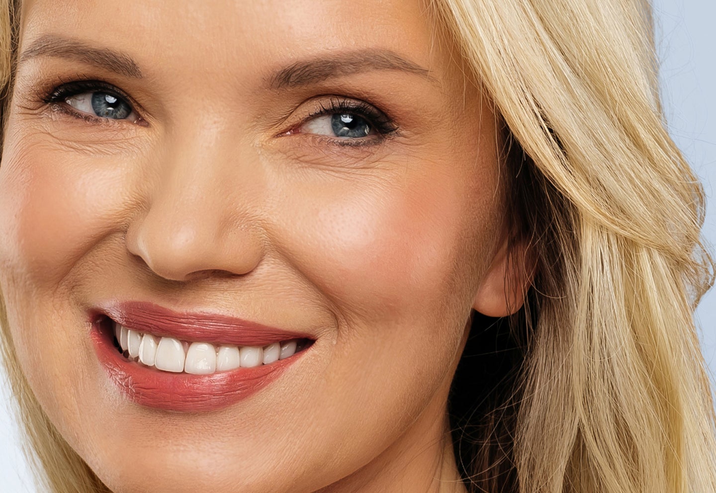A closeup of a smiling woman's face after receiving Botox treatment at Chapter aesthetic studio