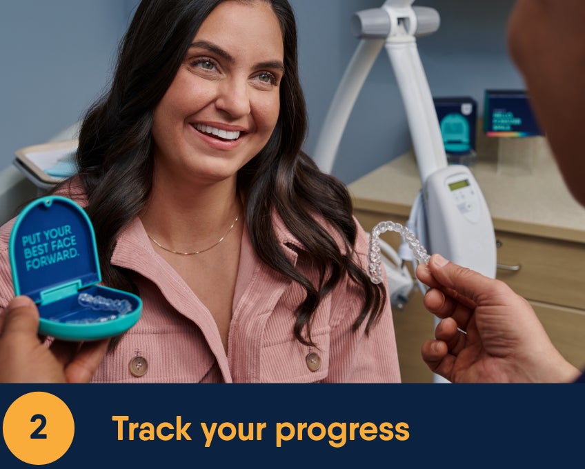 Smiling patient holding an open Motto aligner case with the words “Put Your Best Face Forward” visible inside, while a dental professional offers her a clear aligner in a modern Motto dental office environment.