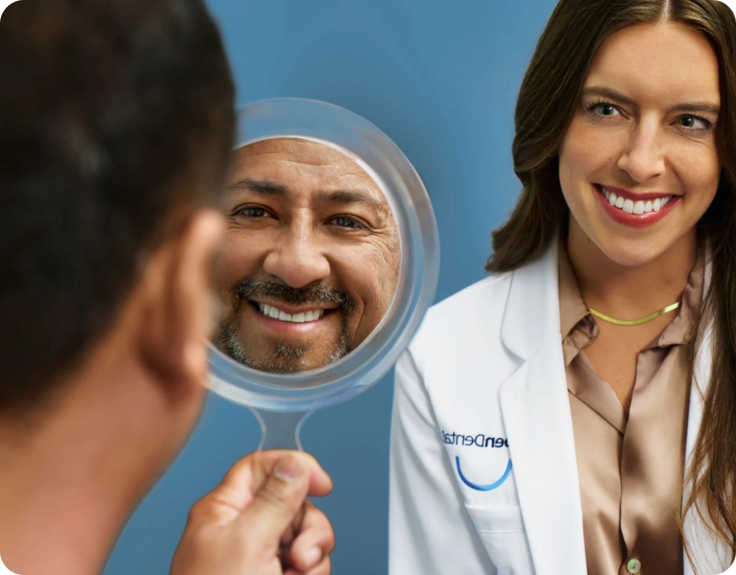 A woman in a lab coat looks at a patient's reflection in a mirror.