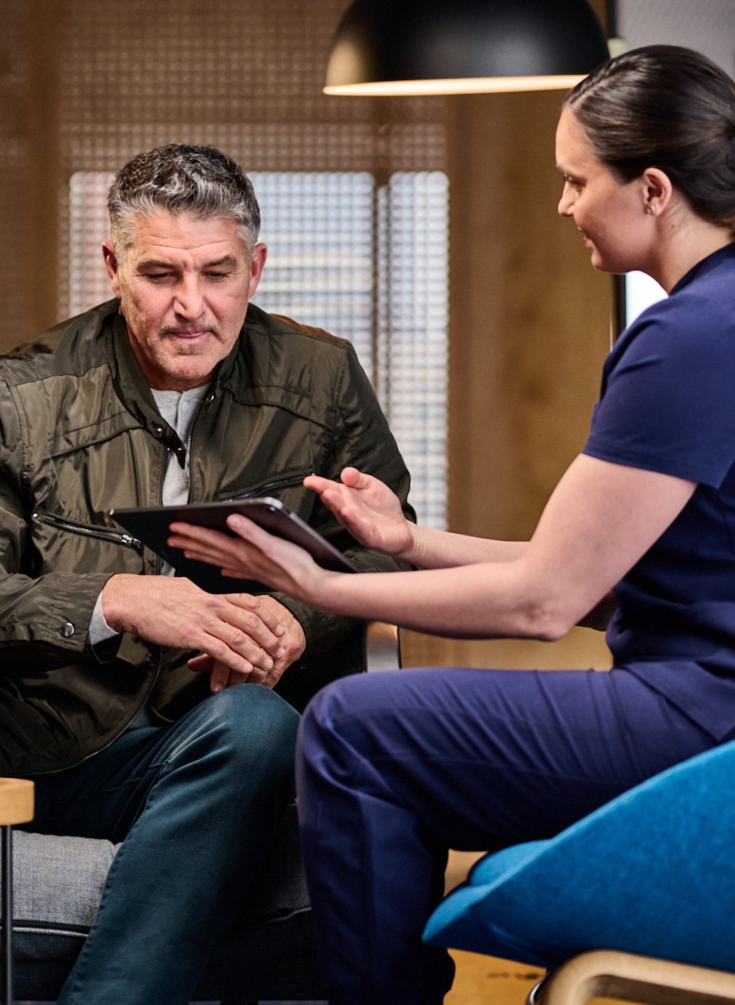 An Aspen Dental professional talks through partial denture treatment with a patient while using an iPad to demonstrate the benefits of upper and lower partial dentures.
