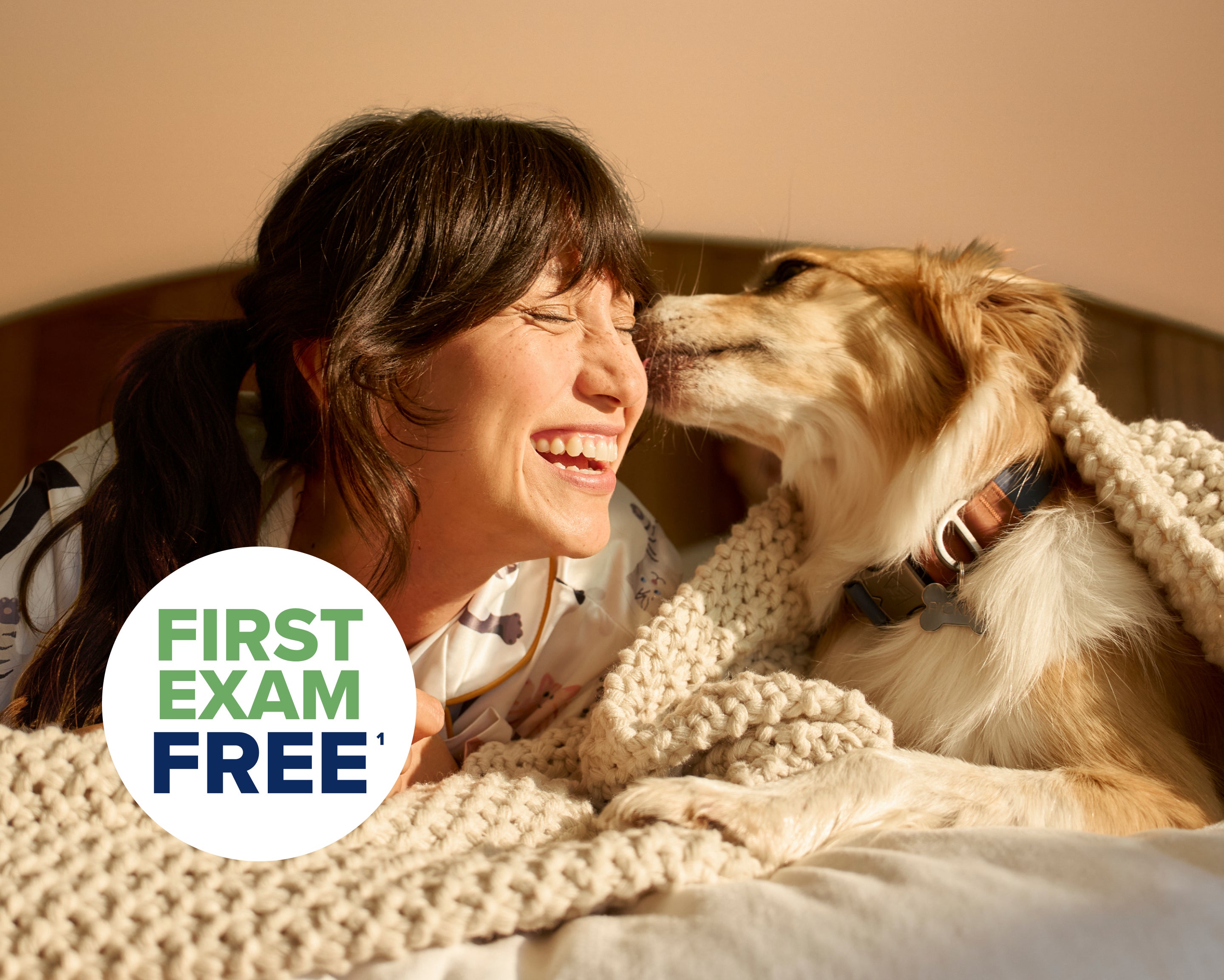 Pet parent cuddling her dog and smiling.