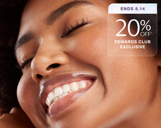 Smiling woman with glowing, hydrated skin gently touching her face—highlighting the benefits of Chapter’s Hydraglow Facial. 