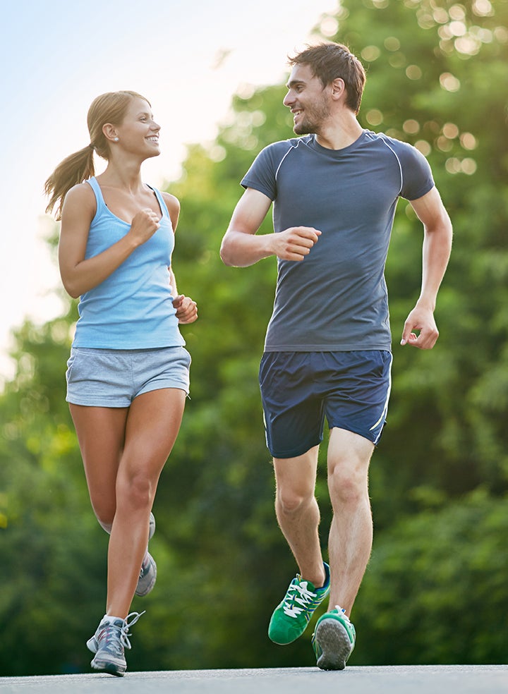 A man and a woman are jogging together in a park