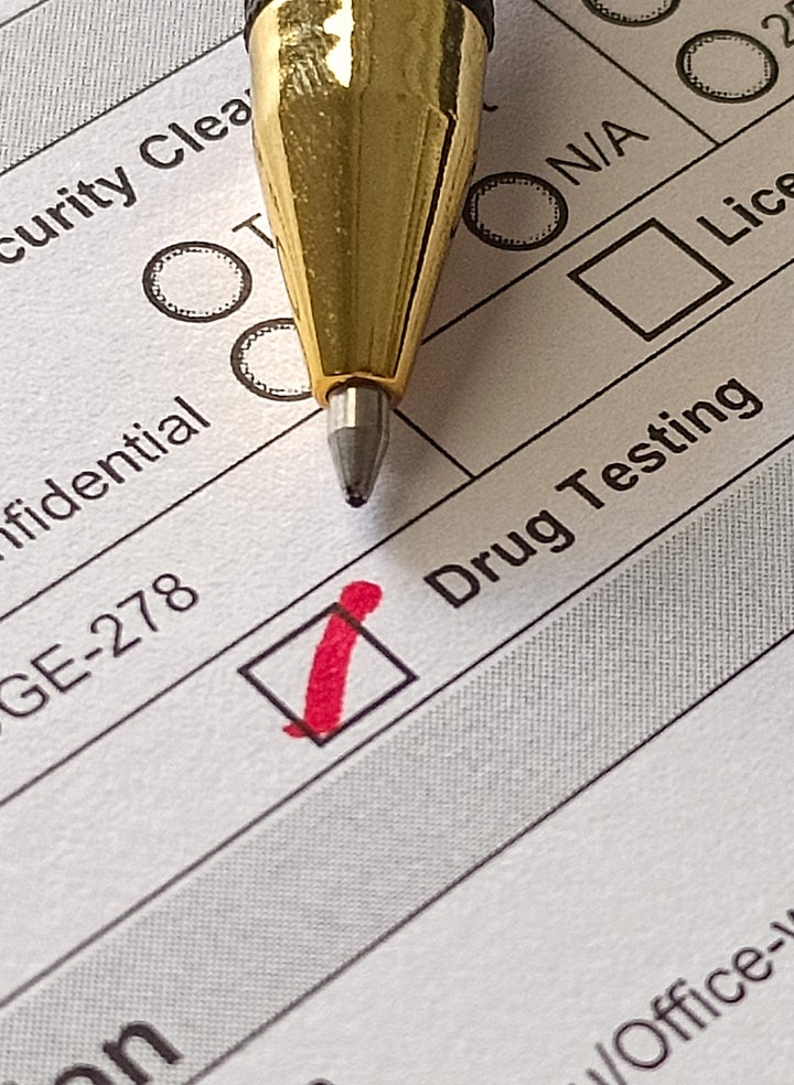 A pen is sitting on top of a form that says drug testing
