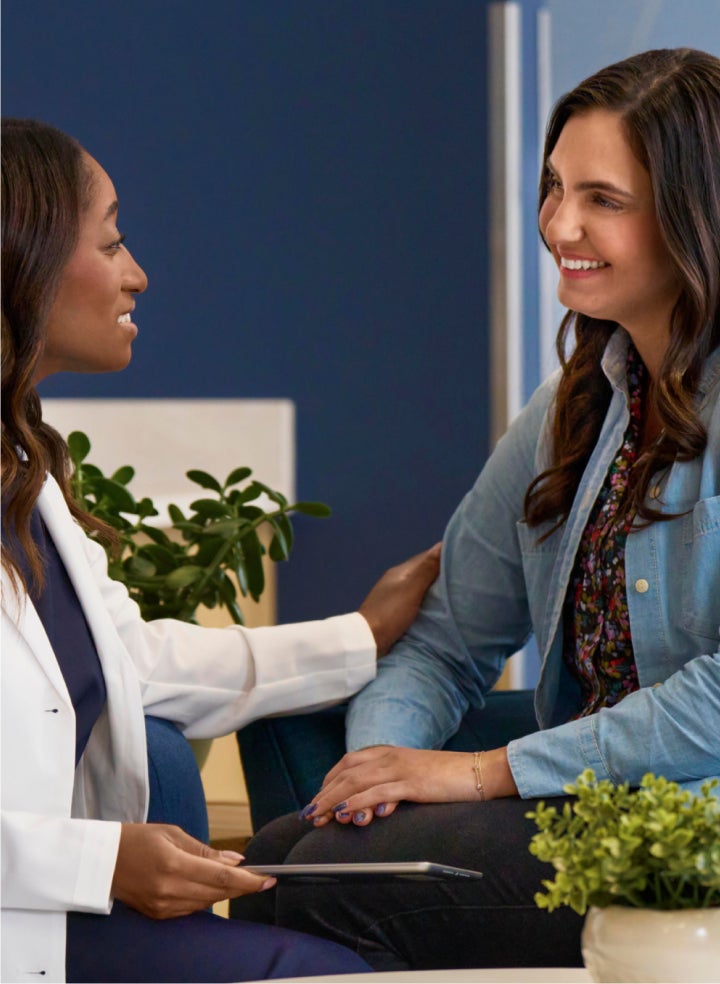 Aspen Dental professional comforting a patient during a consultation, creating a friendly and supportive atmosphere.