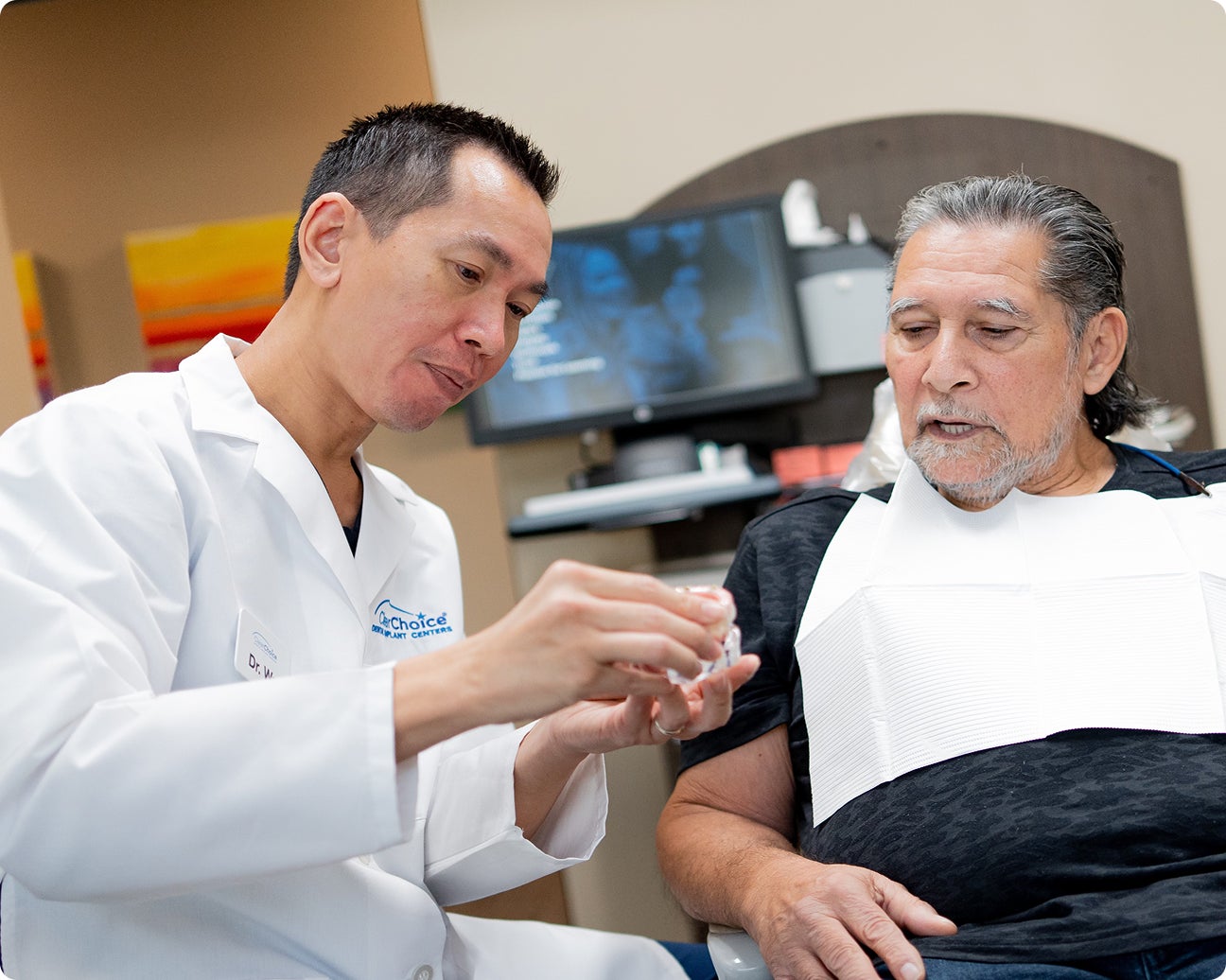 A ClearChoice doctor walking his patient through his treatment plan, and discussing costs and payment options such as the Insurance Assurance program and third-party financing options.