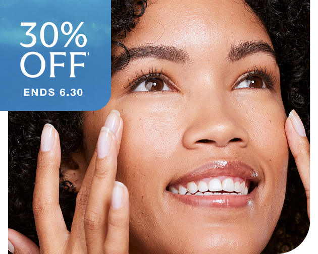 Smiling woman with glowing, hydrated skin gently touching her face—highlighting the benefits of Chapter’s Hydraglow Facial. Summer Kickoff Sale ends 6.30.