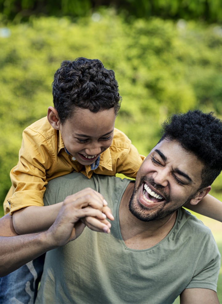 A parent and child playing outdoors.