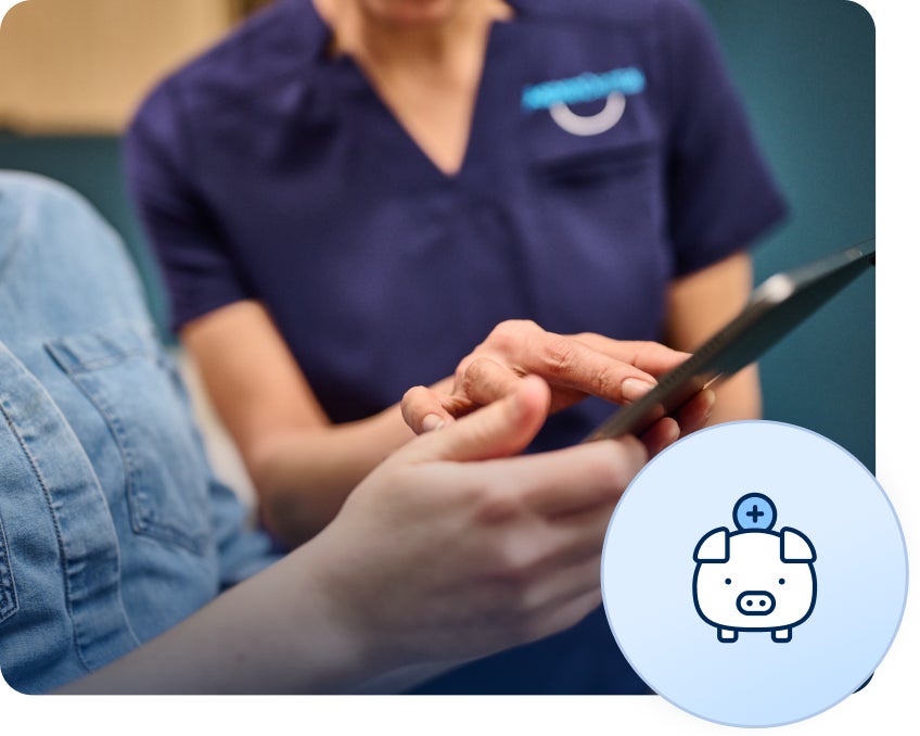 An Aspen Dental professional discussing the cost-effective options of composite veneers with a patient using a tablet, highlighting their affordability.