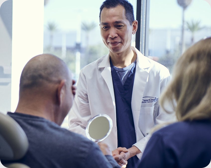 ClearChoice provider team in consultation, reviewing treatment plans. Emphasizes team based approach and expert collaboration.