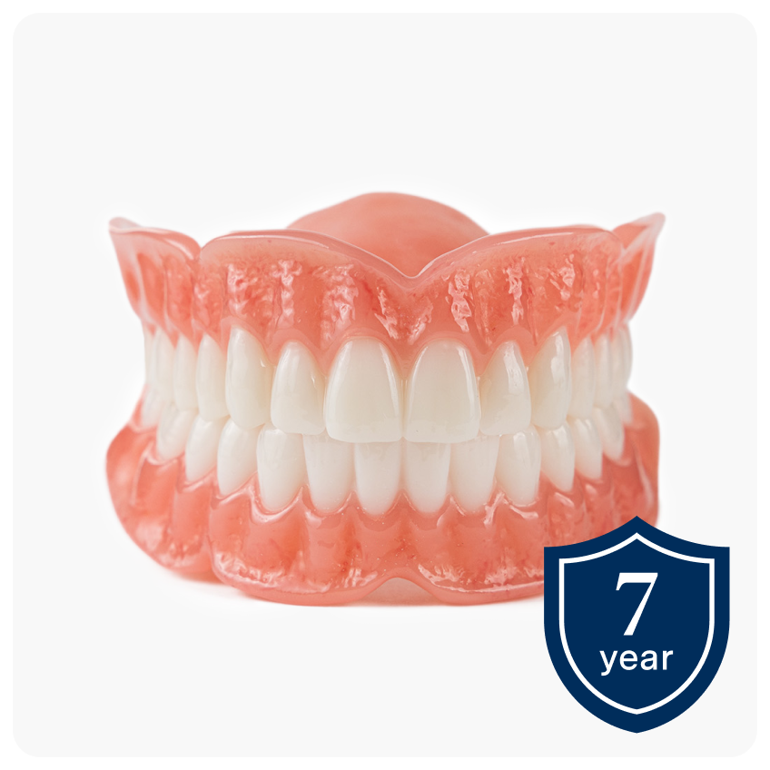 A pair of Aspen Dental Signature Elite dentures displayed on a white background with a 7-year warranty badge in the corner, highlighting premium denture durability and protection.